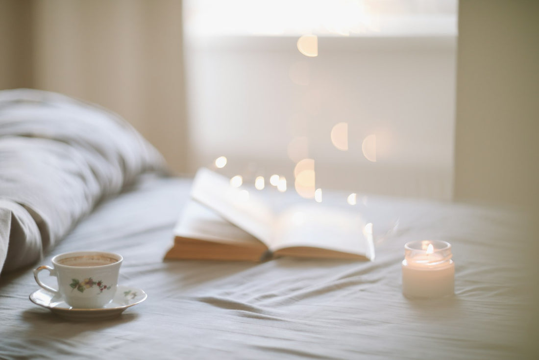 Cozy bedroom morning wellness ritual with coffee and a book