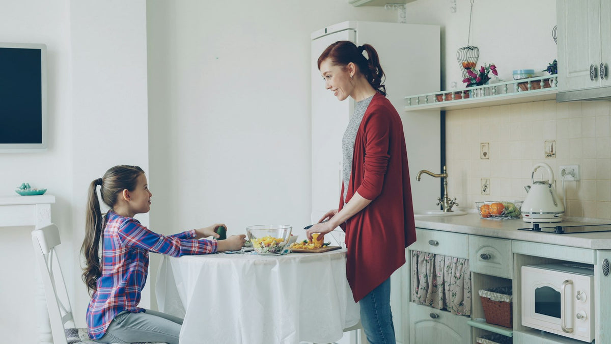 Mother serving her daughter breakfast in a bright kitchen