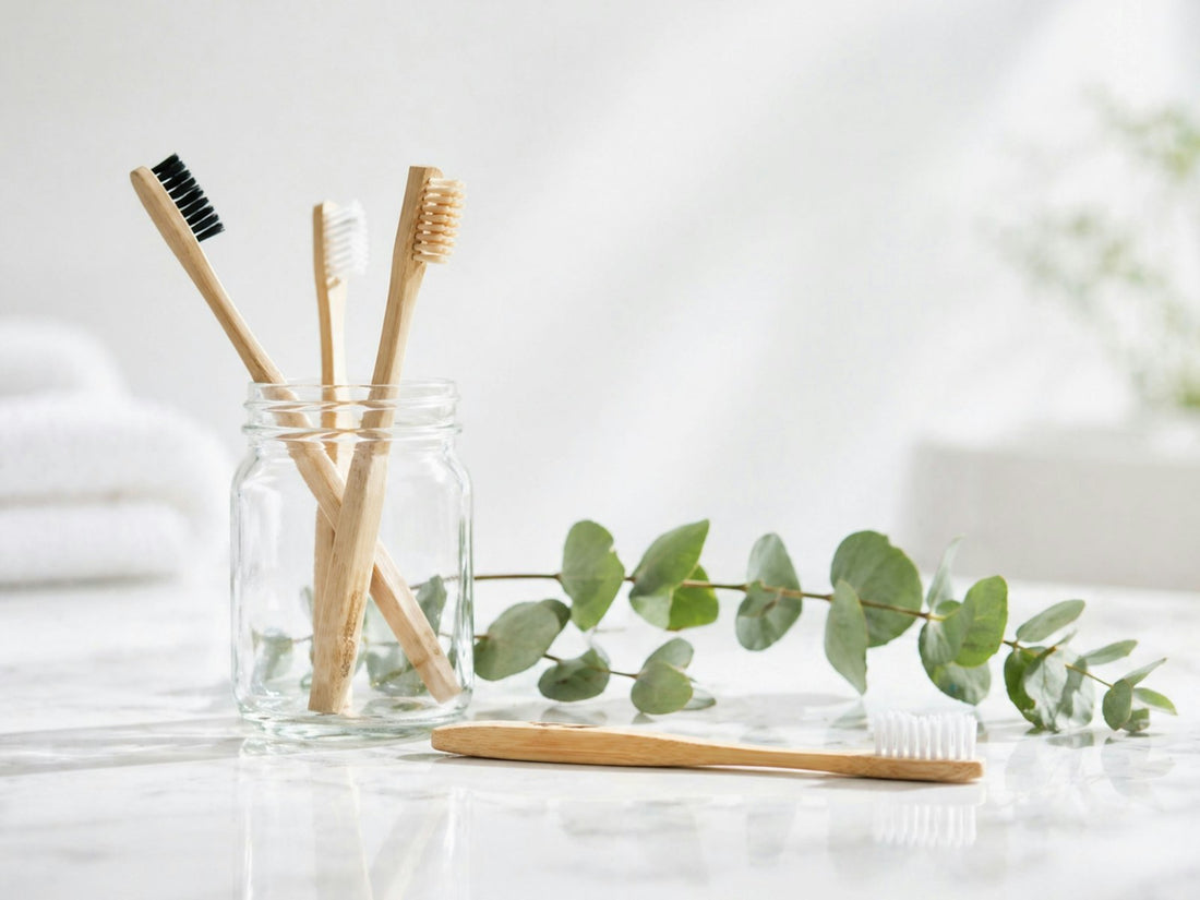 Bamboo toothbrushes in a glass jar with eucalyptus leaves