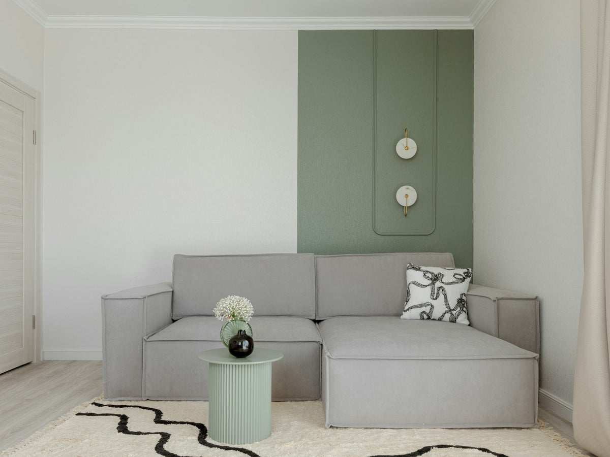Modern living room with grey sofa and green accent wall